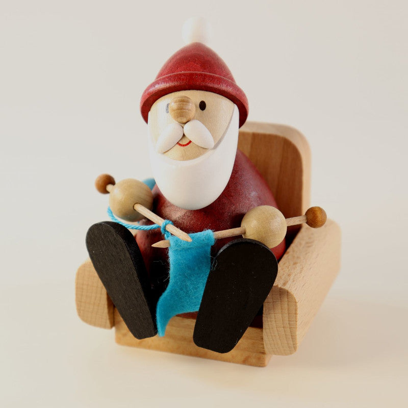 Weihnachtsmann im Sessel strickt Strümpfe